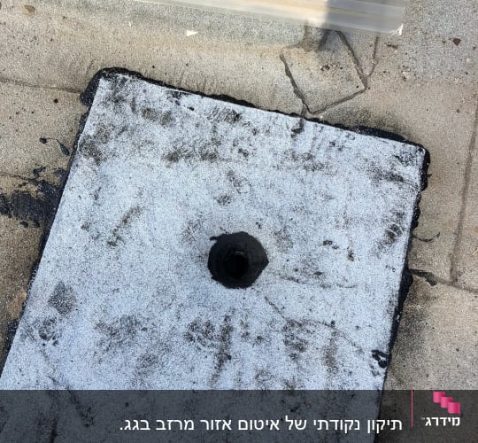 חומר איטום שחור על משטח בטון עם חור במרכז
